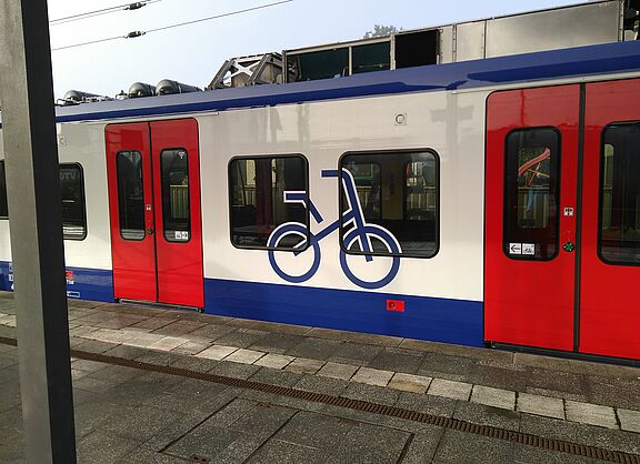 S-Bahn des GVH am Bahnsteig mit großem Fahrradsymbol im Fensterbereich zwischen den Einstiegstüren zum Mehrzweckabeil