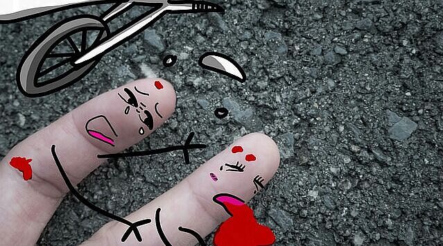 2 Finger mit Gesichtern angemalt, stellen einen Unfall dar, ein Finger weint um den anderen, verletzten Finger. Daneben ein roter Fleck und umgestürzte Räder