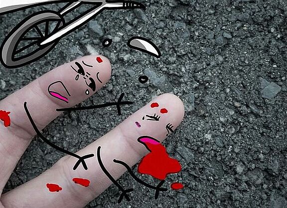 2 Finger mit Gesichtern angemalt, stellen einen Unfall dar, ein Finger weint um den anderen, verletzten Finger. Daneben ein roter Fleck und umgestürzte Räder