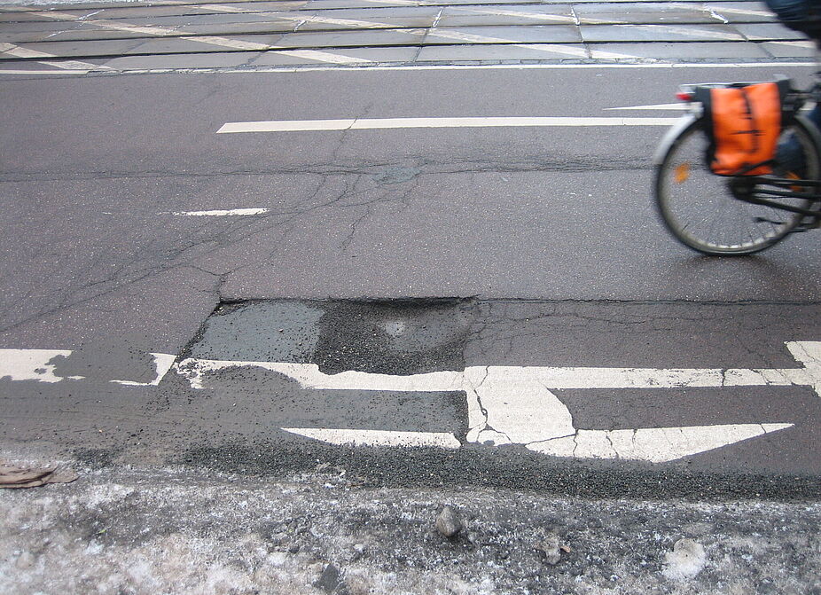 Radfahren in der Stadt: Schlagloch auf der Straße Radfahren in der Stadt: Schlagloch auf der Straße