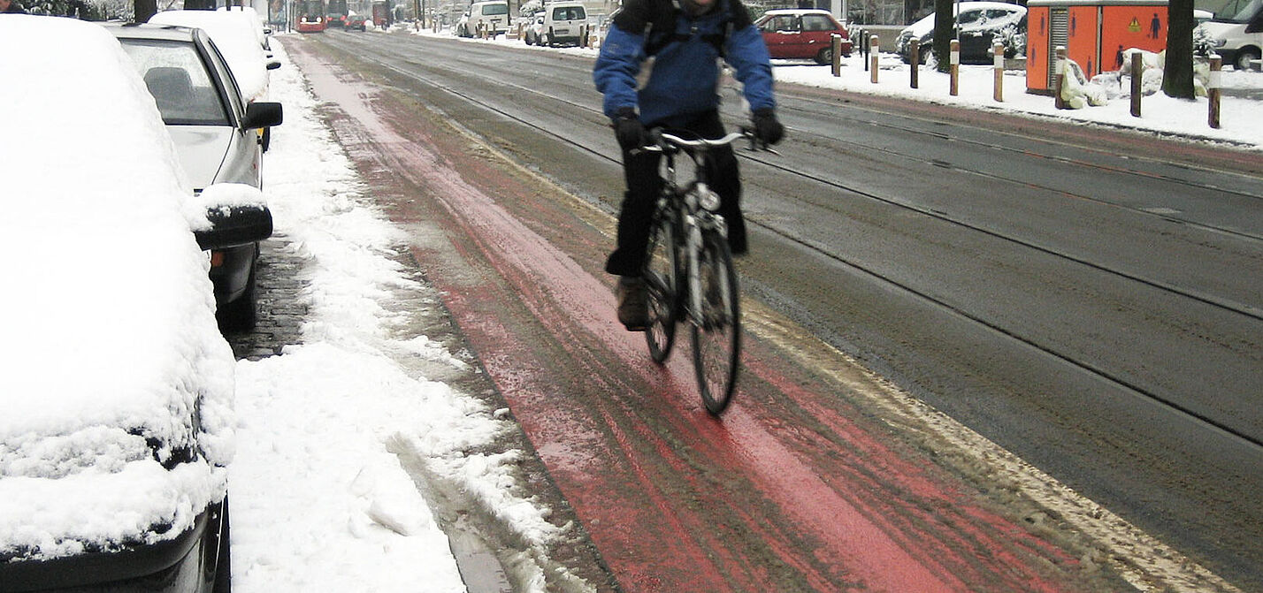 Ein leicht verschneiter Radweg.